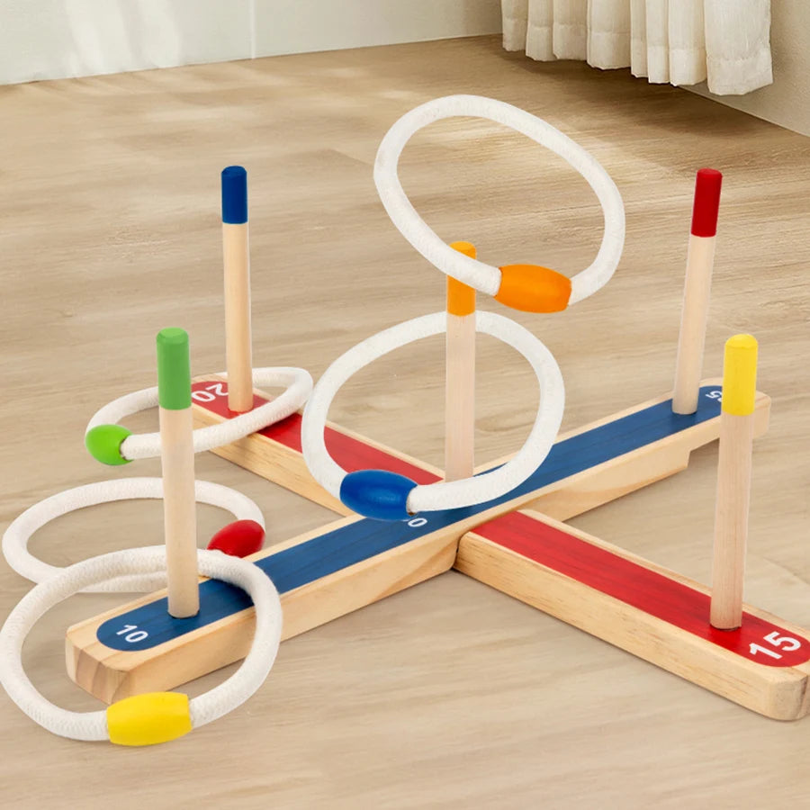 A wooden ring toss game for kids featuring colored wooden pegs and white rings on a light wood surface.