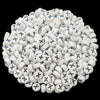 A pile of small white acrylic alphabet letter beads with black markings for jewelry making