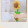 A hand is spraying water from a sunflower bath shower sprinkler toy into a white bathtub.