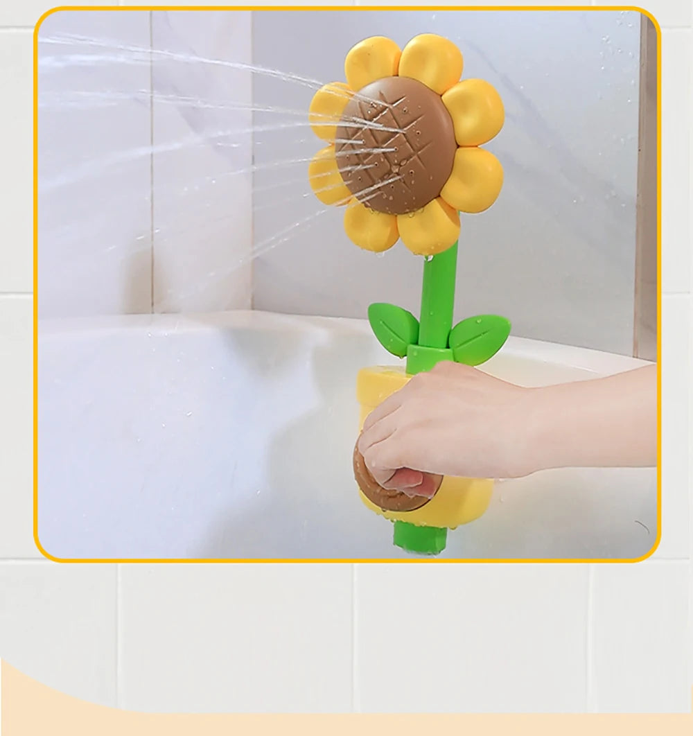 A hand is spraying water from a sunflower bath shower sprinkler toy into a white bathtub.