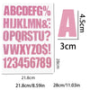 A sheet of pink DIY iron-on heat transfer patches showing an alphabet and numbers for crafting