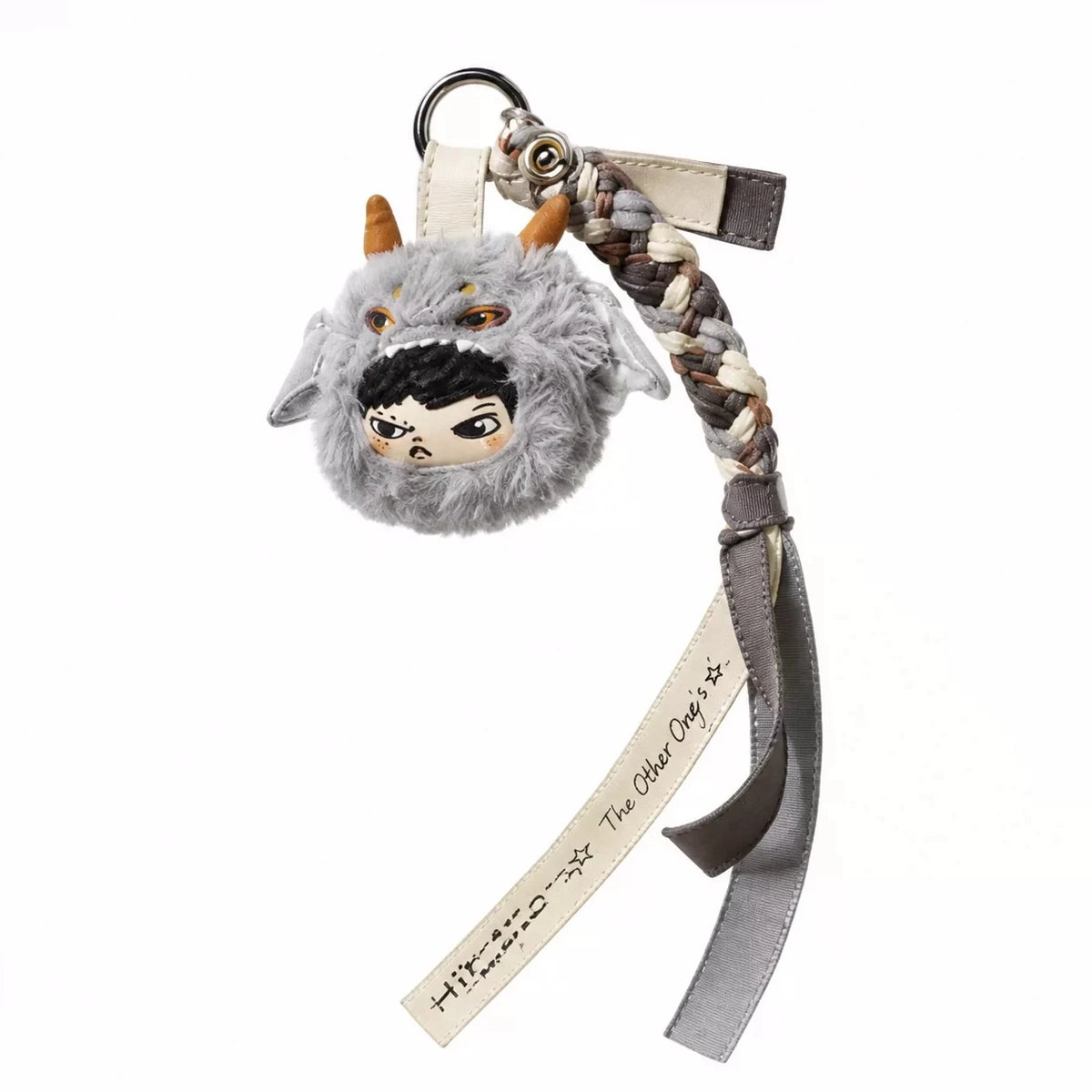 A gray fluffy creature with horns and a face painted on, attached to a leather keychain.