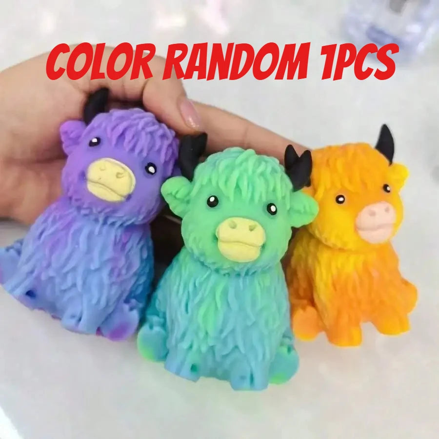 Three random colored squishy toys shaped like Highland cows are held in a hand.