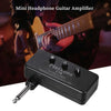 A black mini headphone guitar amplifier is shown next to a musician playing a guitar.