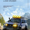 A blue Toyota Land Cruiser model is shown driving off-road in a rugged, natural environment.