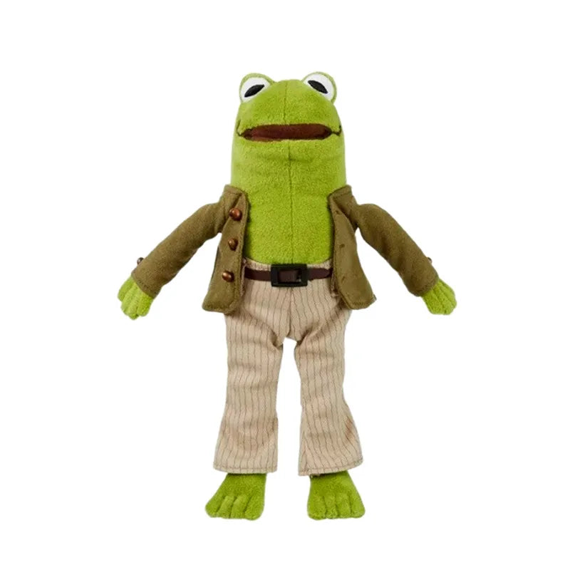A plush toy of a green frog dressed in a brown jacket and beige pants.