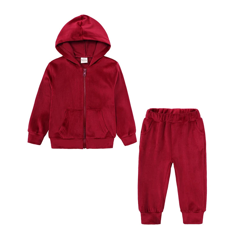 A maroon kids' velvet tracksuit set featuring a hooded zipper jacket and matching pants.