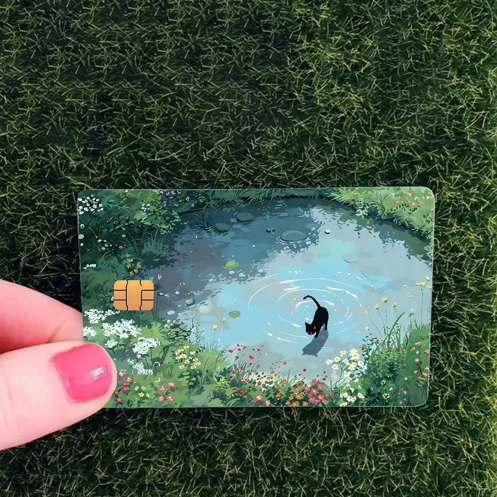 A card featuring a watercolor illustration of a black cat in a pond surrounded by green foliage.