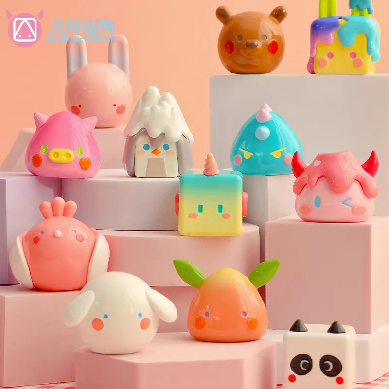 A collection of colorful geometric monster mini bean blind box vinyl figures displayed on pink and white boxes.