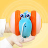 A hand is holding a blue musical pull-along snail toy with orange ears against a yellow background.