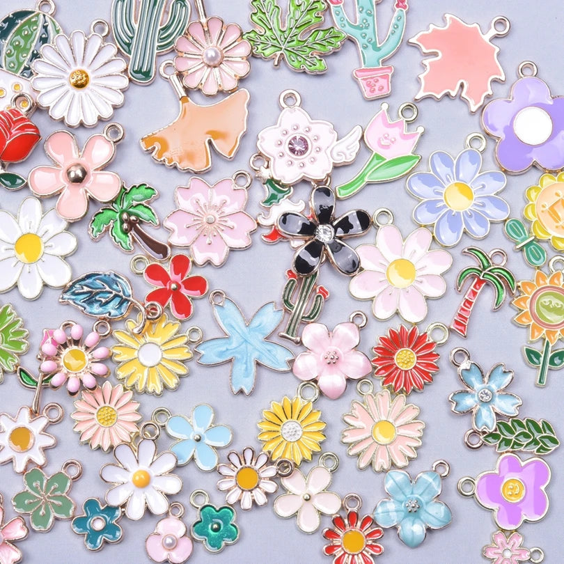 Assortment of gold-tone enamel charms featuring various flowers and cacti for jewelry making