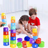 A child is playing with a colorful educational stacking cup game featuring numbers, letters, and shapes.