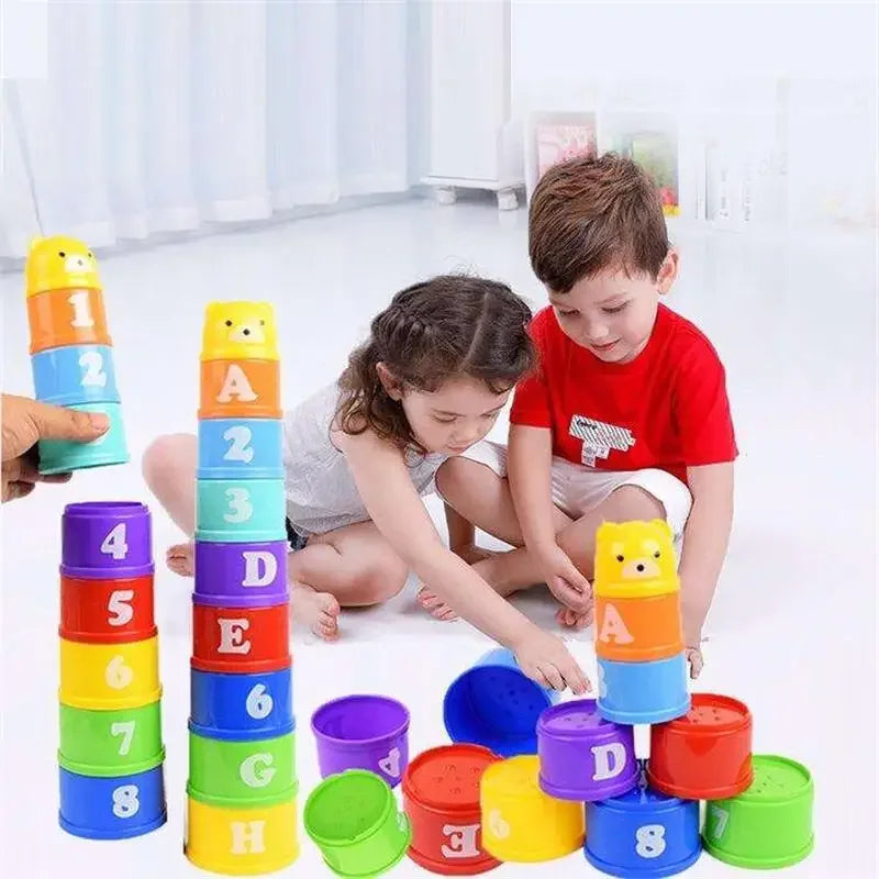 A child is playing with a colorful educational stacking cup game featuring numbers, letters, and shapes.