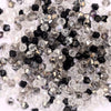 A pile of clear and black faceted crystal bicone glass beads for jewelry making.
