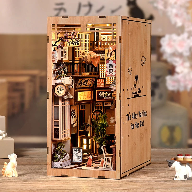 A wooden book nook kit featuring a detailed Japanese alley miniature scene illuminated by LED lights.