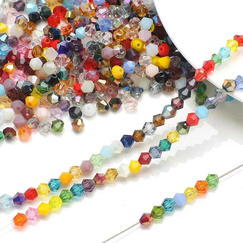 Multicolor faceted glass bicone crystal beads arranged on a white background for jewelry making