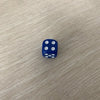 A blue die with five white dots is placed on a light wooden surface.