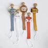 A set of elephant, lion, and fox pacifier holders with clips and various colored fabric strings.