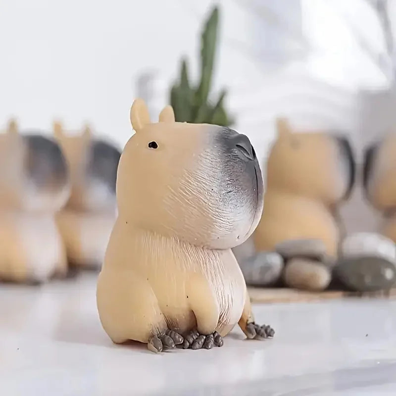 A light beige and gray squishy capybara stress relief toy sitting on a white surface.