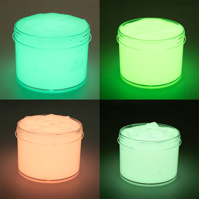 Glow-in-the-dark crystal slime in clear jars, showing bright green and pink luminescence.