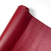 A close-up of a red PU leather material, showing a rolled edge and fine grain texture.