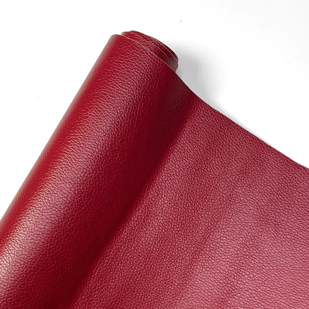 A close-up of a red PU leather material, showing a rolled edge and fine grain texture.
