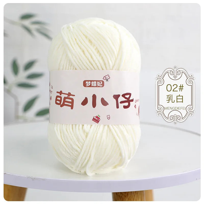 A ball of white chenille yarn with a pink label featuring Chinese characters for knitting and crochet