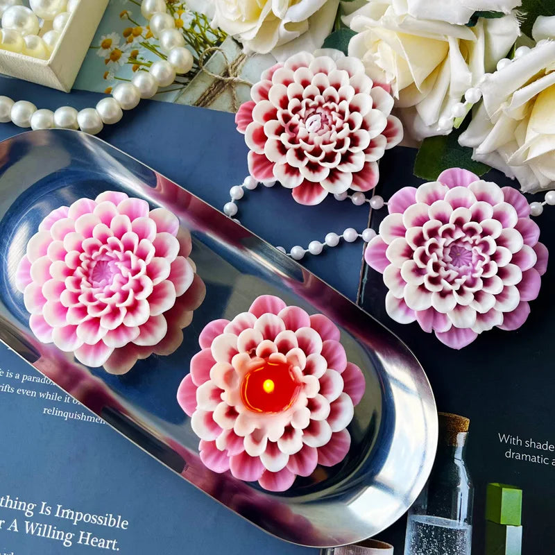 Pink flower silicone mold with an orange candle inside, displayed on a dark blue surface.