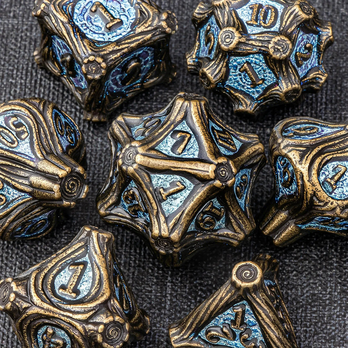 A collection of antique bronze and blue metal dice set for tabletop role-playing games