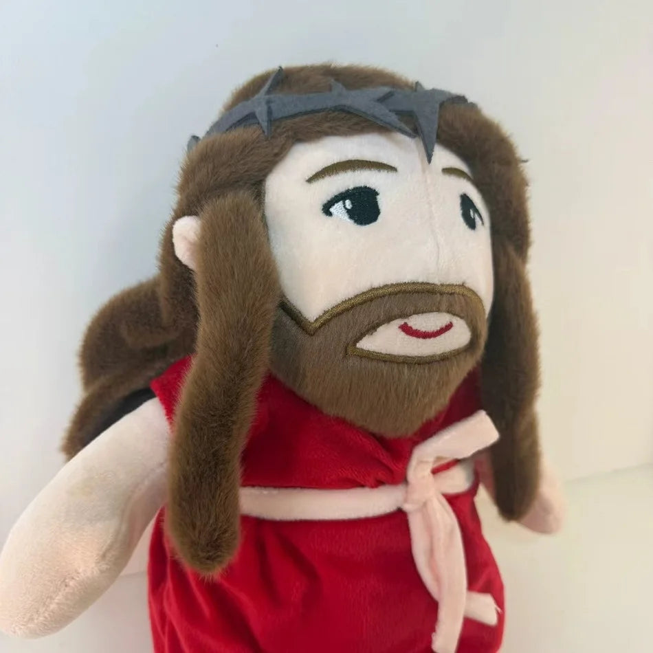 A plush doll resembling Jesus with long brown hair and a beard wearing a red garment.