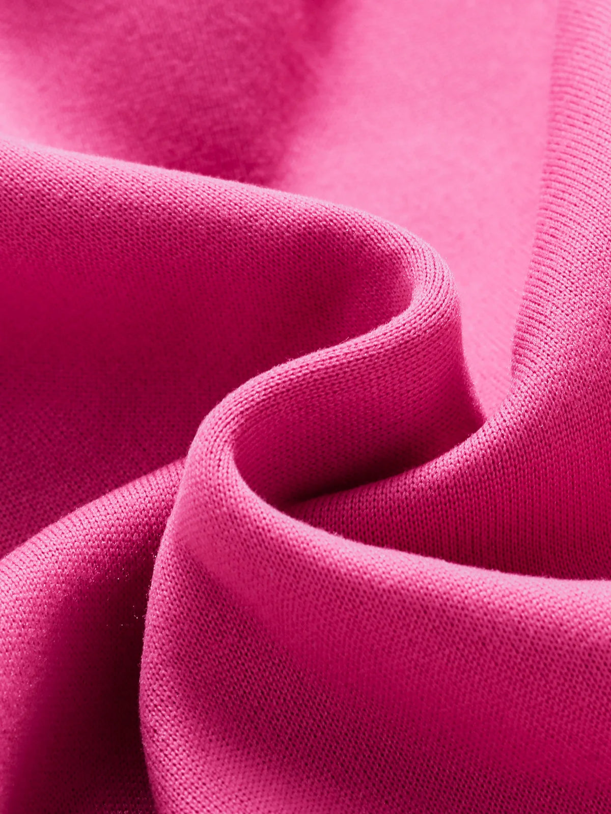 A close-up of a pink knitted cardigan fabric folded and draped.