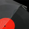 A close-up view of a red vinyl record disc under a clear self-adhesive sleeve.