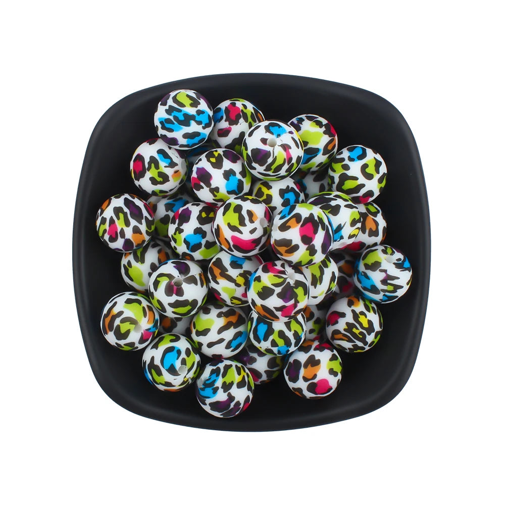 A black bowl filled with small, colorful silicone beads featuring a leopard print and daisy pattern.