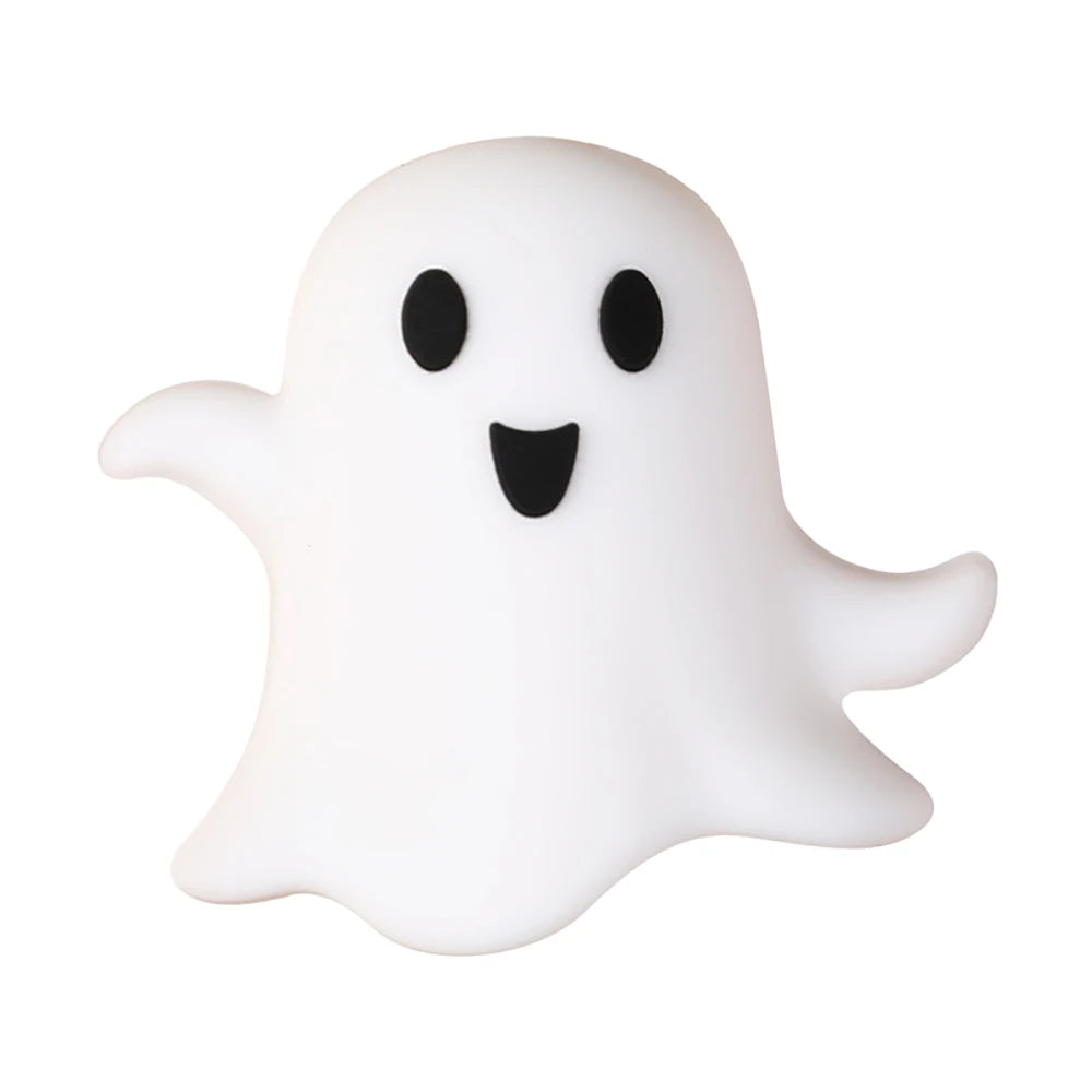 A white silicone bead shaped like a ghost with black eyes and a smiling mouth.