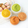Silicone molds of a sun and moon face design for candles and soap making displayed on a white surface.