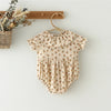 A vintage floral baby girl outfit set featuring a blouse and romper, displayed on a wooden hanger.