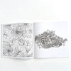 An open page of a mandala coloring book showing intricate floral and leaf patterns for adult stress relief.