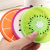A hand holds a set of three colorful fruit pattern PVC coasters: orange, pink, and lime green.