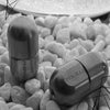 A close-up shot of a metallic magnetic levitating fidget slider resting among small, light-colored pebbles.