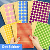 A collection of round self-adhesive dot stickers in various colors like pink, blue, purple, and green are displayed on a dark