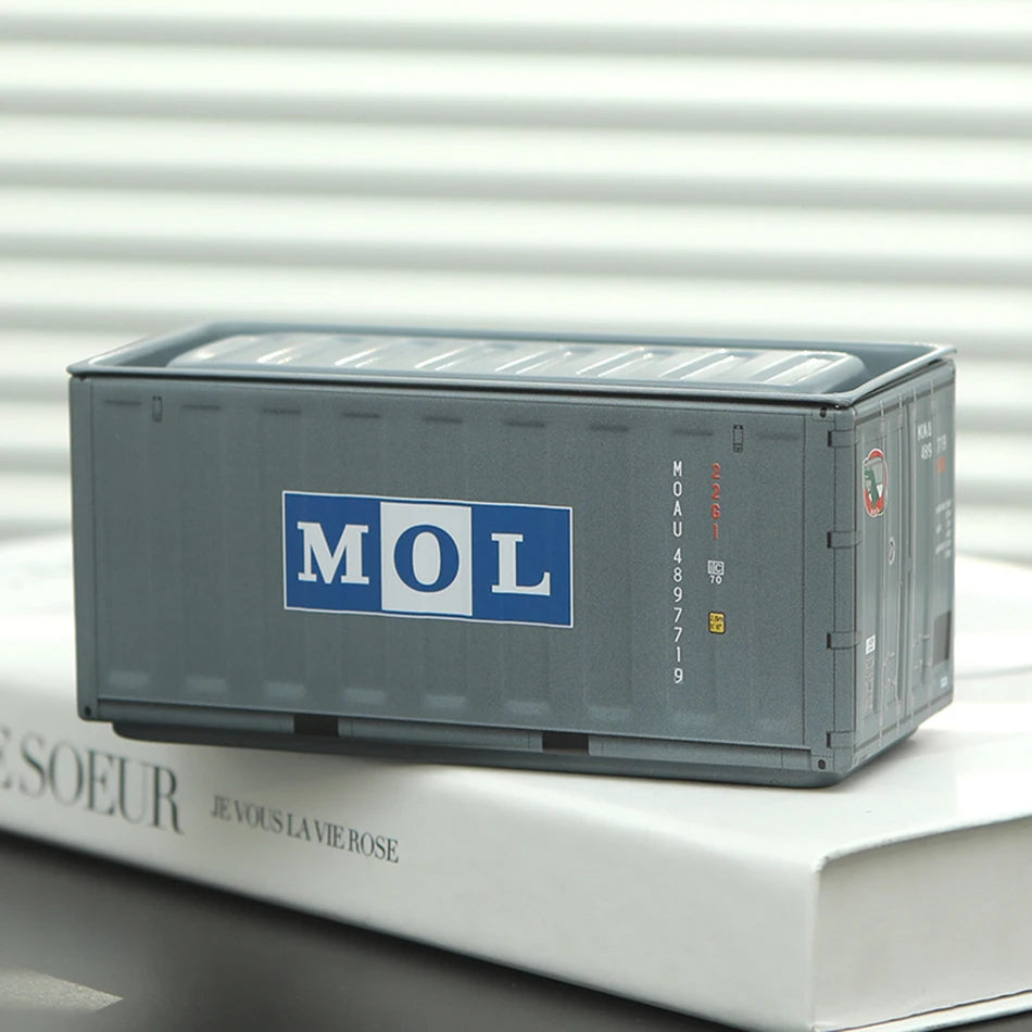 A gray industrial storage box labeled MOL resting on a white surface.