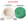 A white silicone mold for making sun face designs in candles and soap, shown next to a green version.