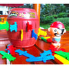 A red barrel decorated with pirate themes and various plastic sword and stab accessories for a party game.