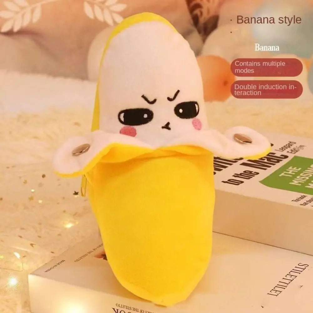 A yellow banana style plush toy with a white body and pink accents is displayed on a box.