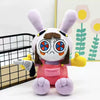 A fluffy purple plush doll resembling a rabbit with large eyes and brown ears.