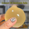 A hand holds a smooth, translucent yellow coconut oil handmade ball.