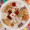 A collection of colorful Y2K acrylic bow and flower beads for DIY jewelry making arranged in a white bowl.