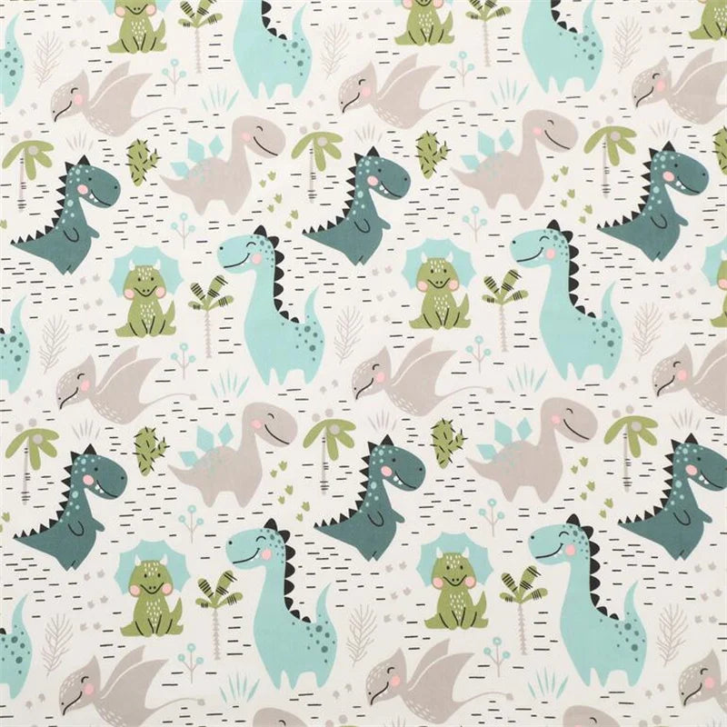 A repeating pattern of various dinosaur silhouettes in shades of green, blue, and gray on a light background.