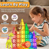 A young girl plays with magnetic building blocks featuring dinosaur and animal figures.