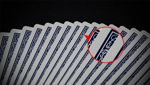 A close-up view of a stack of Bicycle Ultimate Marked Deck poker cards with a red circle highlighting a marked card.